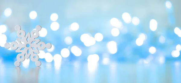 Tahta kar taneleri Bokeh ile mavi bir arkaplana yakın.