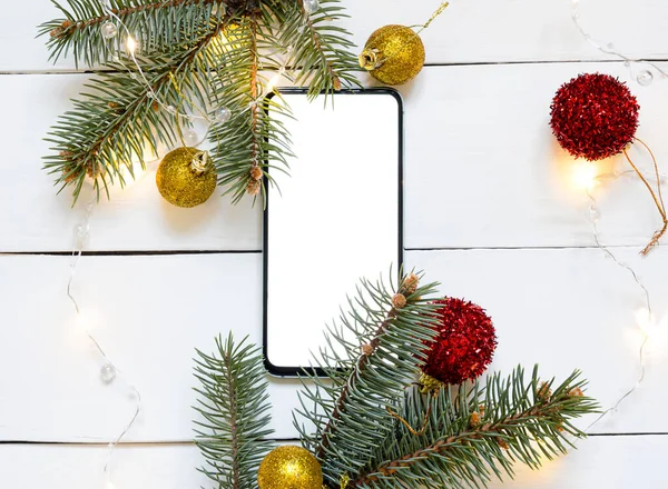 Рождественская Сосна Телефон Белом Деревянном Фоне Гирляндой — стоковое фото