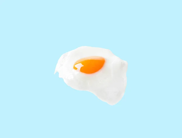 Uovo fritto su sfondo blu. Moda alimentare concetto minimalista Foto Stock Royalty Free
