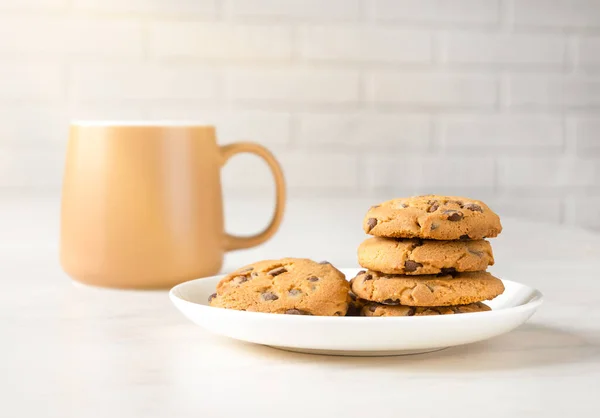 Raies du matin, biscuits et thé pour le petit déjeuner en tasse marron — Photo