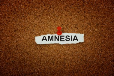 Üzerinde amnezi yazan buruşuk bir kağıt parçası mantar panoya tutturulmuş. Kapat..