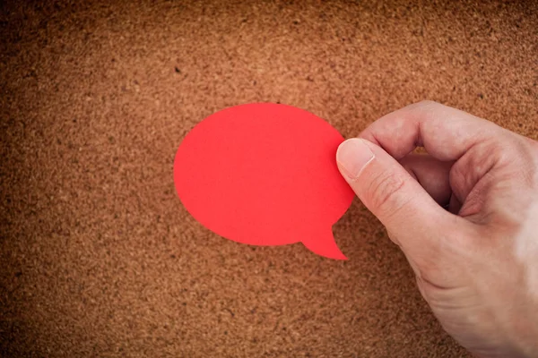 Man Holding Red Speech Bubble His Hand Cork Board Close — Fotografia de Stock