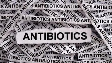 Üzerinde antibiyotik yazan gazete şeritleri. Siyah ve beyaz. Kapat..