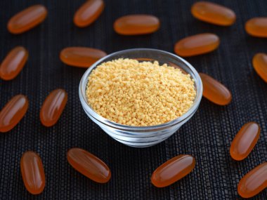 Etrafında soya lecithin softgeller olan cam bir kasede soya lecithin. Alçakgönüllülük. Kapat..