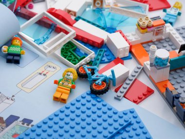 Tambov, Rusya Federasyonu - 9 Şubat 2022 Bazı Lego parçaları ve minyatür figürler bir masanın üzerinde açık bir kitapçık ile. Kapat..