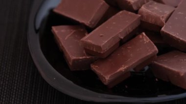 Bir kasede kırılmış siyah çikolata parçaları. Kapat.