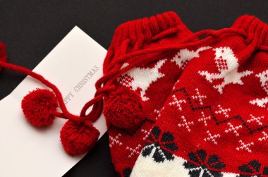 Yeşil arka planda mutlu noel mandalları ve kozalaklı dallarla dolu bir kart.