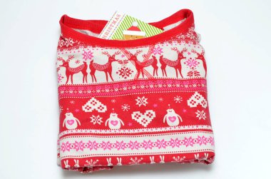 Beyaz arka planda katlanmış bebek pijamaları ve noel kartı