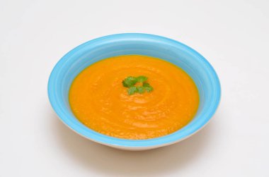 Beyaz arka planda kabak püresi çorbası.