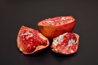 parlak sulu kırmızı nar ve siyah bir yakın plan üzerinde tohumlar.