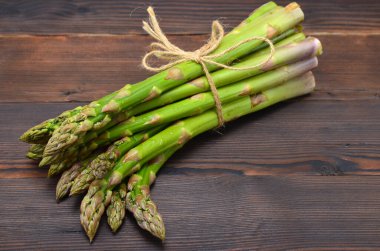 Ahşap arka planda taze kuşkonmaz.