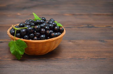 Ahşap bir masanın üzerinde kuşüzümü sepeti.