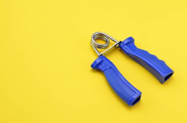 Sarı arka planda mavi saplı el kaslarını çalıştırmak için genişletici