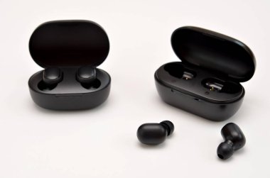 Beyaz arka planda iki çift modern kablosuz kulaklık.