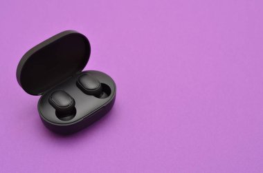box with wireless headphones on a purple background and space for text