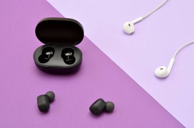 gadgets, wired and modern wireless headphones on a lilac background