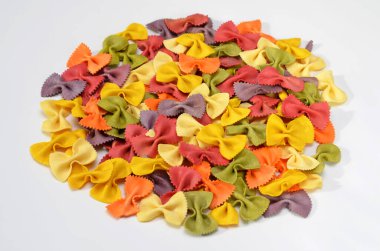 colorful farfalle pasta with natural extracts isolated on white background