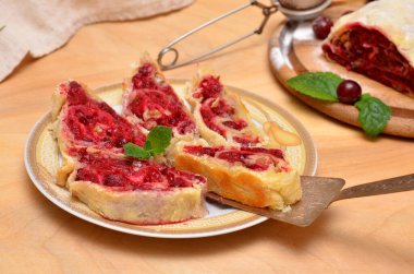 sliced homemade Viennese strudel with cherry filling on a plate 