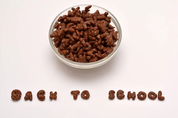 chocolate flakes in a bowl and the text back to school from the letters of the alphabet on a white background