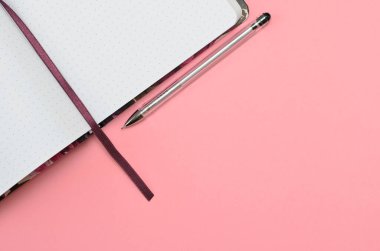 Pembe arkaplanda bir kalem, boş bir sayfa, kopyalama alanı olan bir defter aç