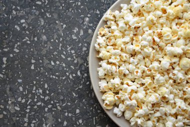 Siyah arka planda kasede patlamış mısır. Üst Manzara. Metnin için boş yer.