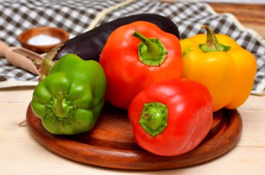 Taze kırmızı, yeşil ve sarı biberler ahşap arka planda