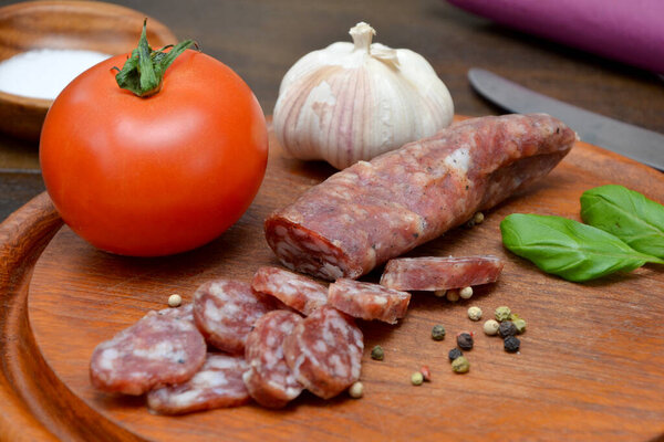 raw sausage and vegetables on the wooden board 