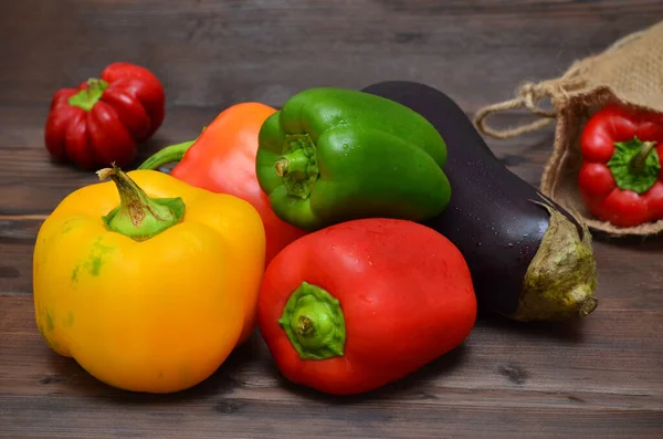 fresh red, yellow and green peppers on wooden background