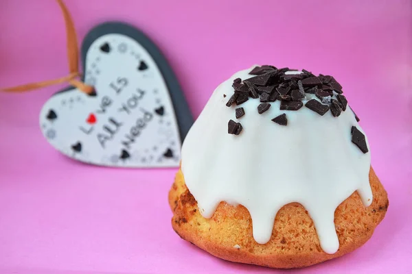 Pembe arka planda kremalı lezzetli bir pasta.