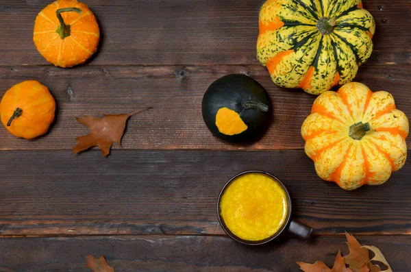 黄金のミルクとカボチャと秋の葉を背景にしたカップフラットレイ — ストック写真