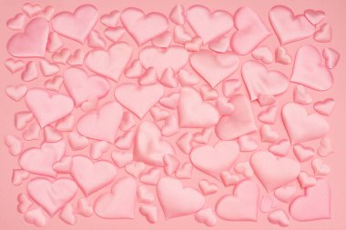 Bulmaca stiline göre sıralanmış, farklı boyutlarda şehvetli pembe saten kalplerin güzel narin arka planı. Sevgililer Günü arkaplanı.