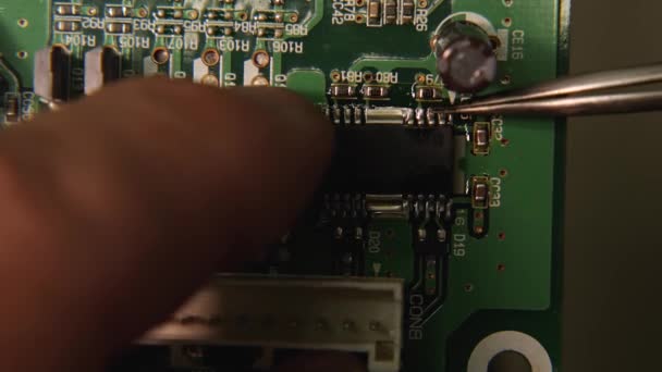 用镊子在电子电路板上安装芯片的修理工的特写镜头 计算机 电话和电视修理店 — 图库视频影像