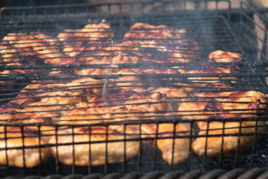 Kömür ızgarasında ızgarada kızarmış tavuk kanadı. Kömürlerden duman çıkıyor. Yakın plan. Seçici odaklanma. Arka bahçe pişirme kavramı