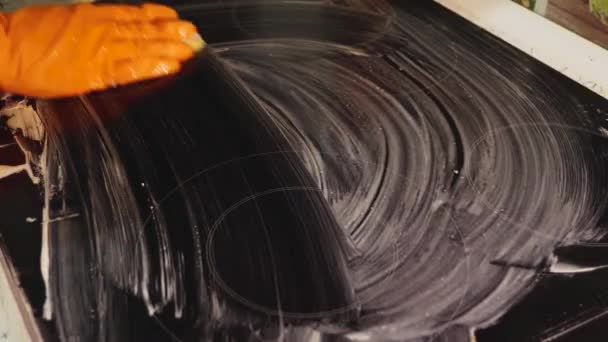 橙色手套的特写 海绵清洗炉顶 选择焦点 电炉家庭清洁的概念 — 图库视频影像