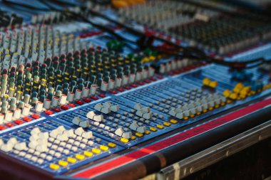 Kayıt konsolu. Bir müzik festivalinde ses mühendisi masasını karıştırıyor.