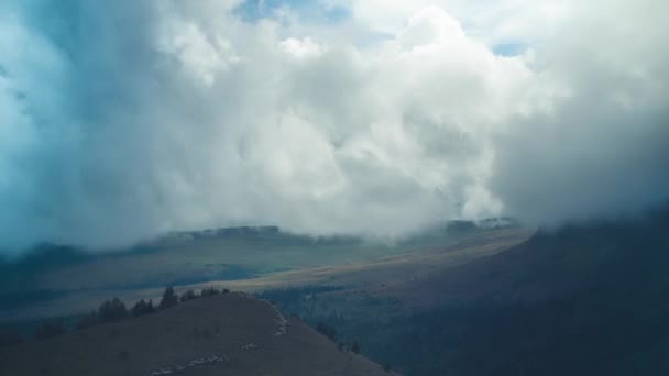 白い雲の山の谷の上を旋回のタイムラプス 低い雲が山を越えている — ストック動画