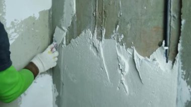 Tamirci duvarı bir malayla sıvamış. Yakın plan. Odaları bitirme kavramı