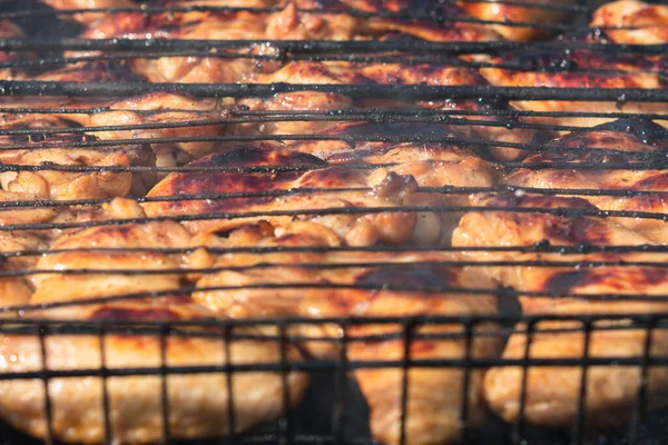 グリルの上に金色の地殻で鶏の羽を揚げ 石炭から煙が立ち上がる 接近中だ 選択的フォーカス 裏庭料理のコンセプト — ストック写真