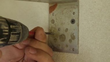 Kendi kendini beceren bir tornavidayı elektrikli tornavidayla vidalamaya yakın çekim. İç dekorasyon kavramı