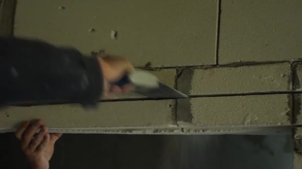 Een mensenhand zaagt een deur uit schuimblok met een handzaag. Een close-up. Het concept van de renovatie van de ruimte. — Stockvideo