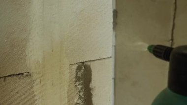Sprey tabancayla köpük bloklama makinesine sprey sıkarken yakın çekim. Zaman aşımı görüntüleri. Odaları bitirme kavramı