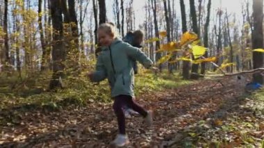Sonbahar ormanında köpekle koşan bir kız çocuğu. Mutlu çocukluk kavramı