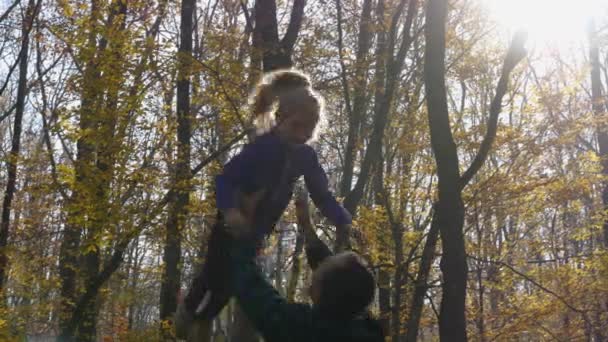 Ein Mann Wirft Ein Mädchen Vor Die Kulisse Des Waldes — Stockvideo