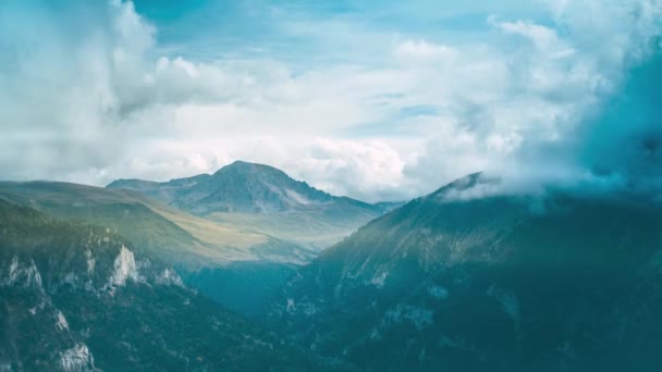 雪原のある山と 雲や霧に包まれた森に覆われた峡谷 スムーズなカメラアプローチ 山岳タイムラプス — ストック動画