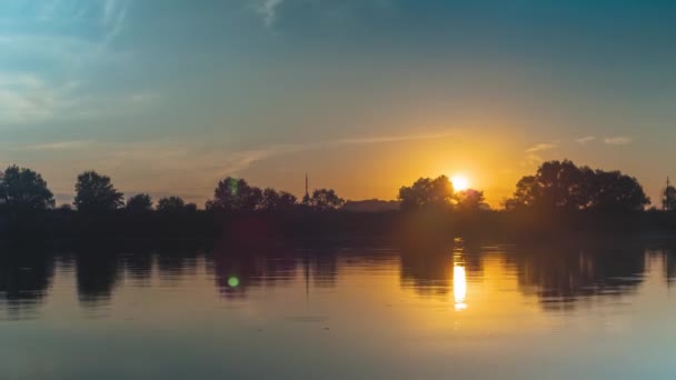 夏日的夕阳西下在河边 水面上反射出树木和云彩 躲在森林后面的橙色太阳球 自然的流逝 — 图库视频影像