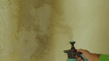 Sprey tabancalı beton bir duvara astar uygulamaya yakın çekim. Oda bitirme konsepti