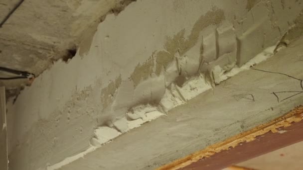 修理工は小さなトロールで壁に石膏を適用しています 接近中だ 部屋を終えるというコンセプト — ストック動画