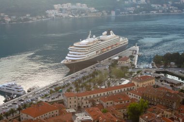 Bir yolcu gemisinin arka planında kiremitleri olan taş evler. Bokokotorska Körfezi 'nde akşam. Karadağ 'da turizm kavramı