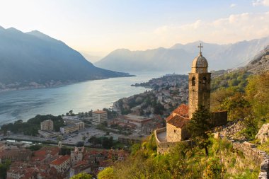 Deniz ve dağların arkasındaki Hristiyan tapınağı. Gün batımında Bako-Kotor Körfezi 'nde. Karadağ 'da turizm kavramı