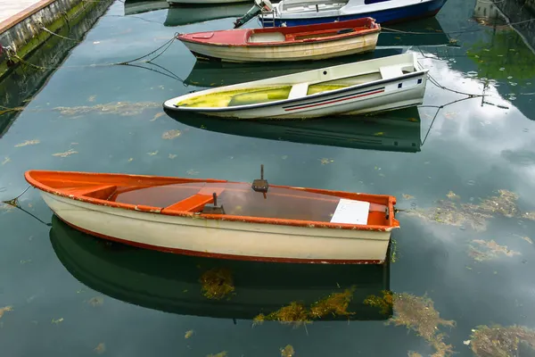 港にはロープで水で満たされた古いボートが係留されています 海藻や雨滴と海の水 — ストック写真